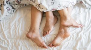 The feet of a couple in bed