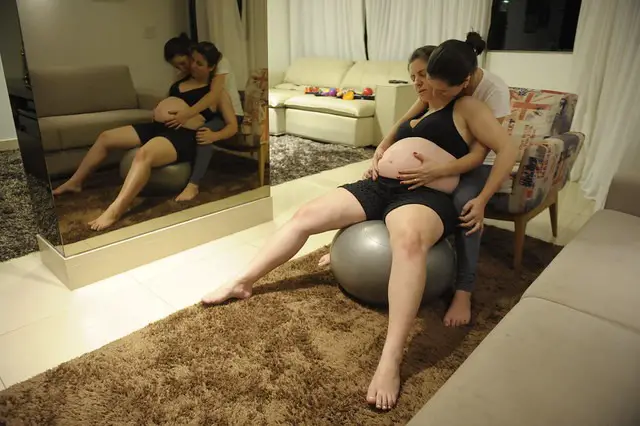 Doula helps mother on birthing ball